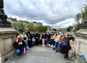 Tour group from HEC Paris MBA along the Seine River in the heart of Paris discovers the history of women in Paris