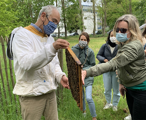 Apiculturist Alain Bébon invites participants to feel the heat generated by the bees' movements 